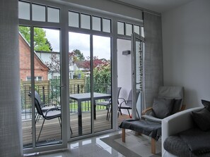 Una sala moderna con un gran ventanal corredero que da a un patio al aire libre.
