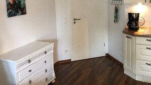 A kitchen with a white cabinet, a white dresser, and a coffee maker. - 2-zi.-fewo für 4 Personen im 1. OG Links (Graal-Müritz)