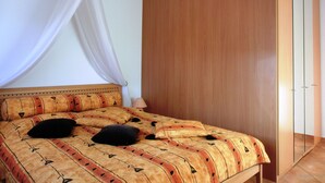 Un dormitorio con cama, dosel, armario y lámpara de noche.
