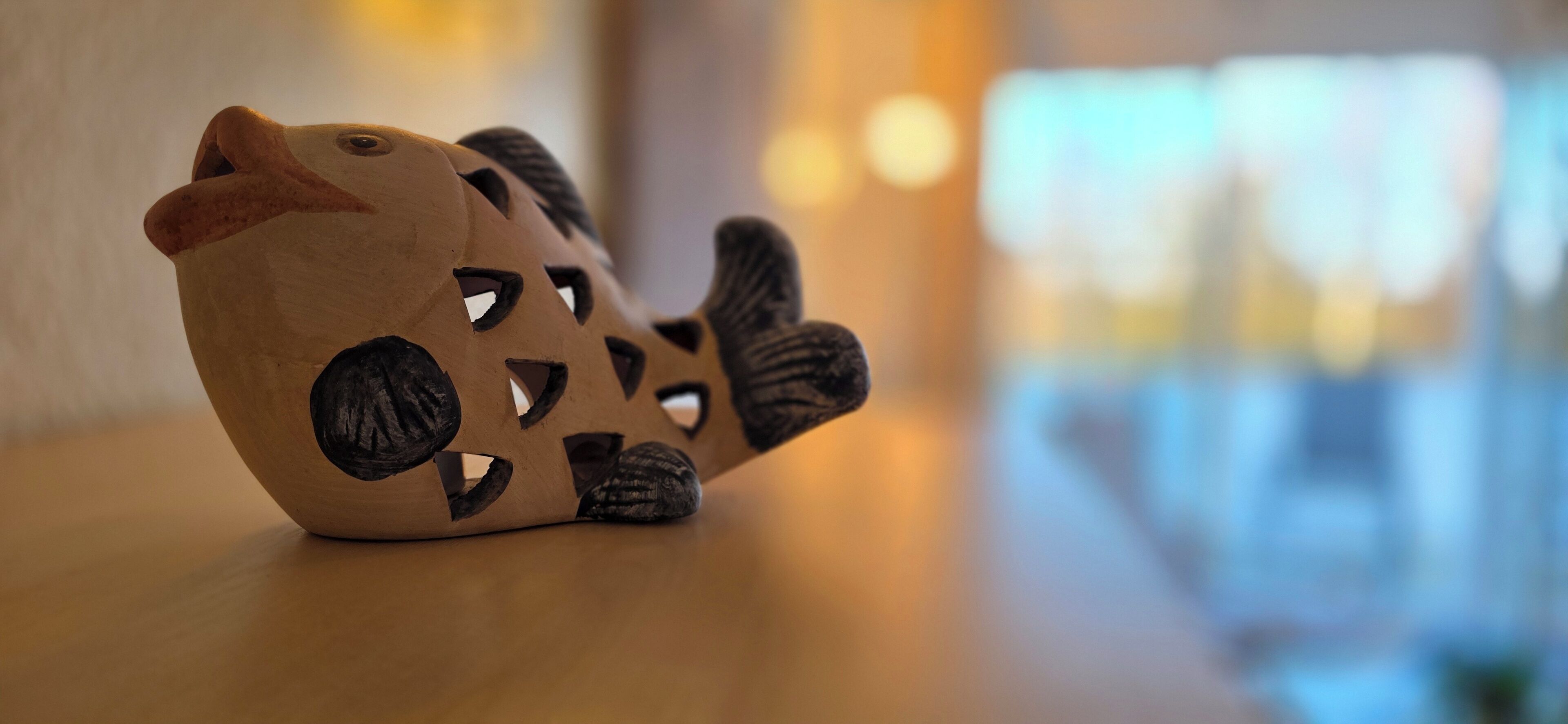 Una escultura de madera de un panda acostado sobre una mesa.