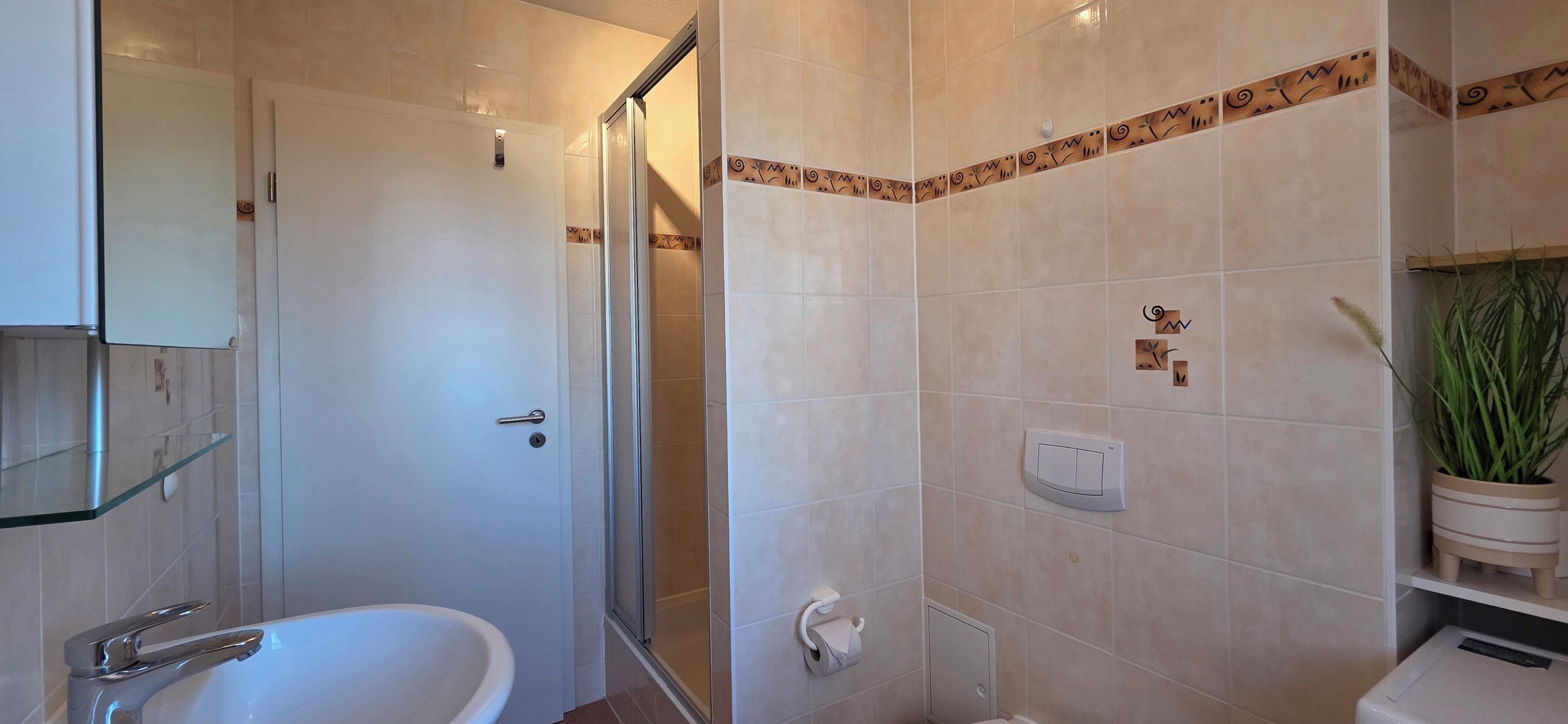A bathroom with a bathtub, a glass shower enclosure, a toilet, and a sink.