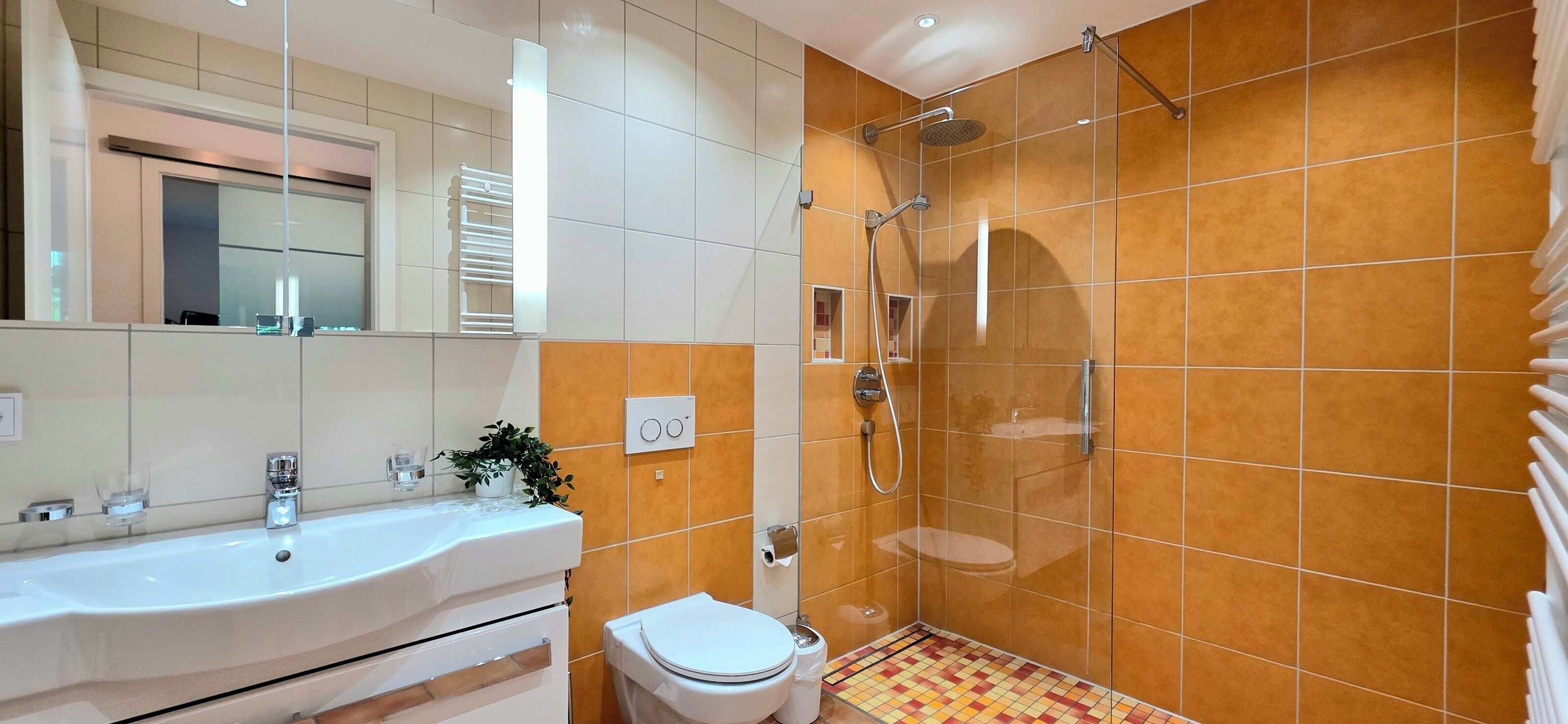 A bathroom with a white sink, a toilet, and a shower with a glass door.