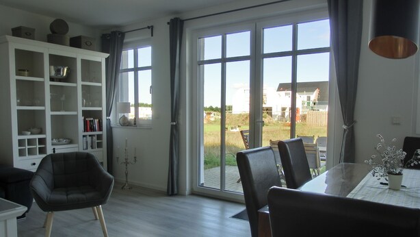 Un salón amplio con comedor, ventanas grandes y vistas al exterior.