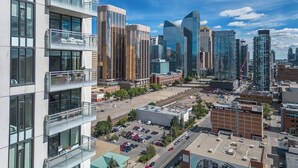 A modern urban area with high-rise buildings, a parking lot, and a McLean & Partners office building. - Stylish Corner Unit. Views & Comfort. Feel at Home (Calgary)