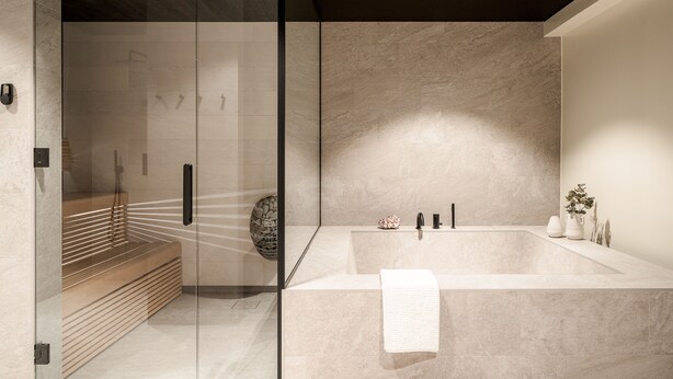 Un baño moderno con una bañera grande, cabina de ducha de vidrio y un banco de madera.