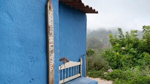 A blue building with a wooden bench and a sign reading 'Mirador de la Reina.'