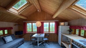 Un accogliente chalet con zona pranzo, cucina e salotto.