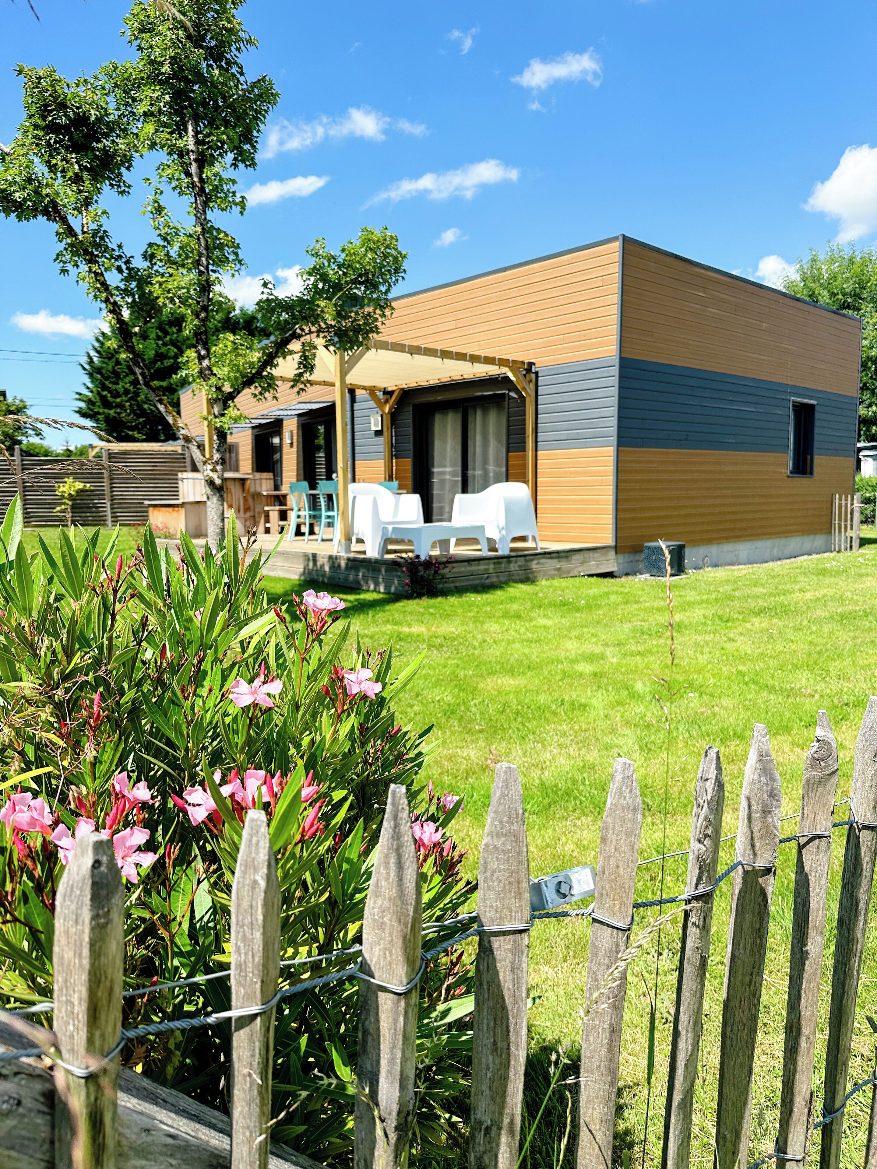 A modern two-story house with a covered patio and outdoor seating area.