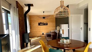 Un'area pranzo moderna con tavolo in legno, sedie gialle e lampadario.