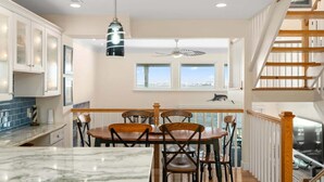 A kitchen with a dining area, a view of the city, and a staircase.