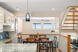 A kitchen with a dining area, a view of the city, and a staircase.