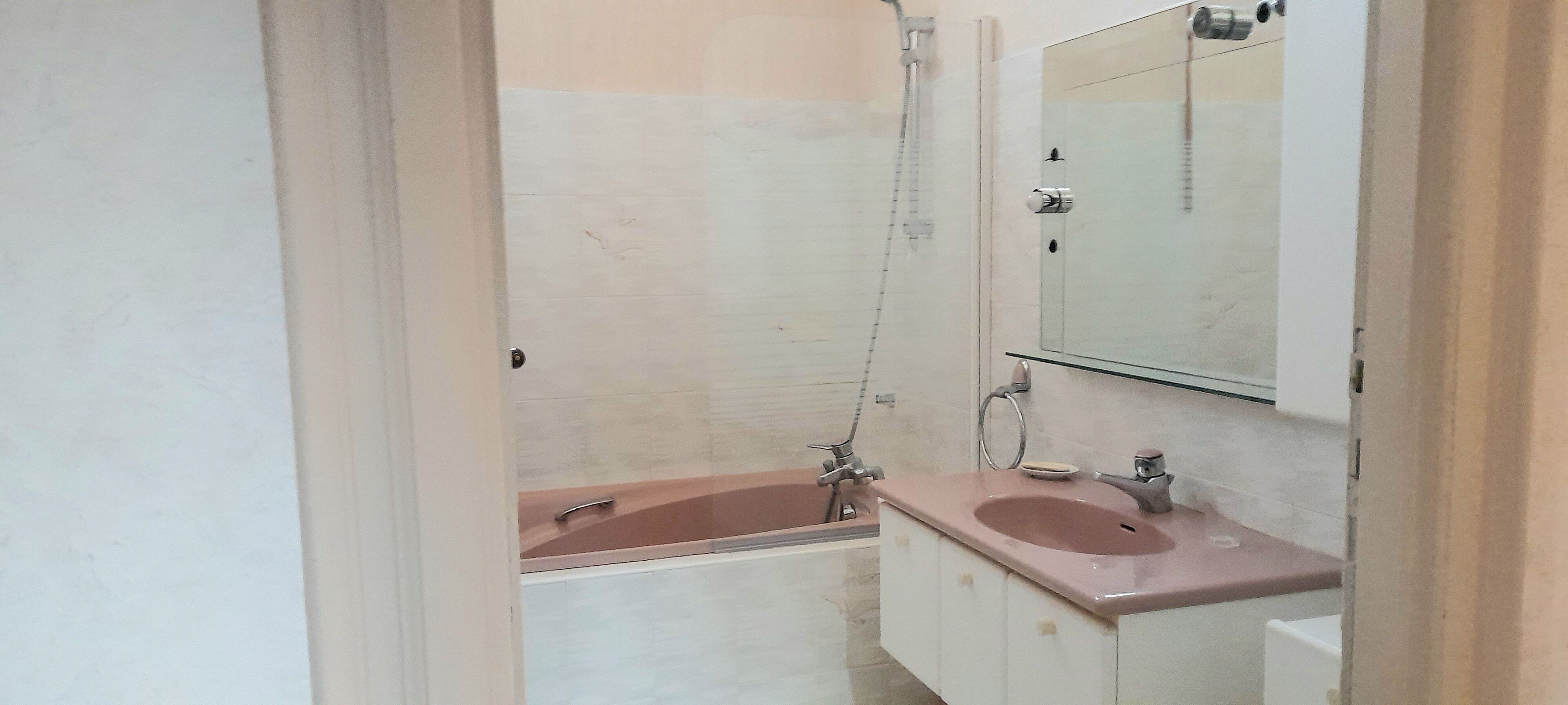 Un baño con bañera, lavabo y espejo.