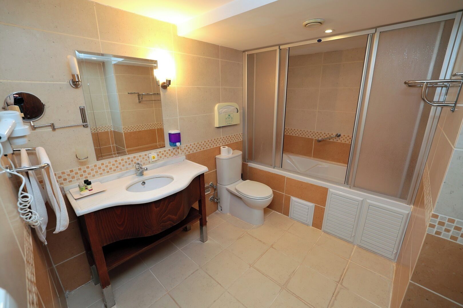 A bathroom with a sink, toilet, and shower area.