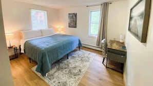 A bedroom with a bed, bedside tables, a rug, a desk, and a chair. - Spacious 4 BR with theater, close to Airport (Fairbanks)