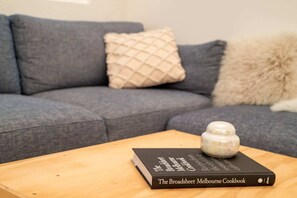 Um livro intitulado 'The Broadsheet Melbourne Cookbook' sobre uma mesa de madeira.