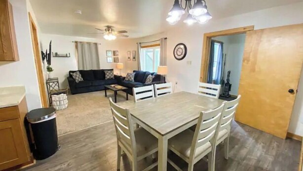 Un espacio habitable compacto con comedor, sofá y zona de cocina.