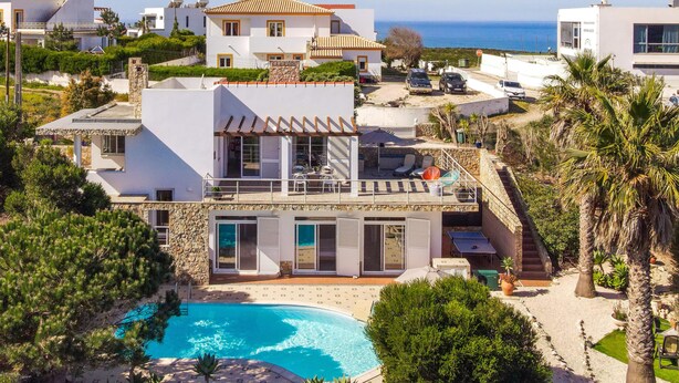 Una villa moderna con piscina, un balcone e vista mare.