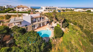 Una villa moderna con piscina, immersa nel verde e con vista sul mare.