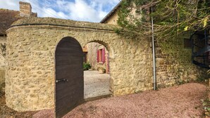 A stone building with a large arched doorway and a small porch area.