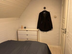 Cozy bedroom with a single bed, dresser, and closet space.