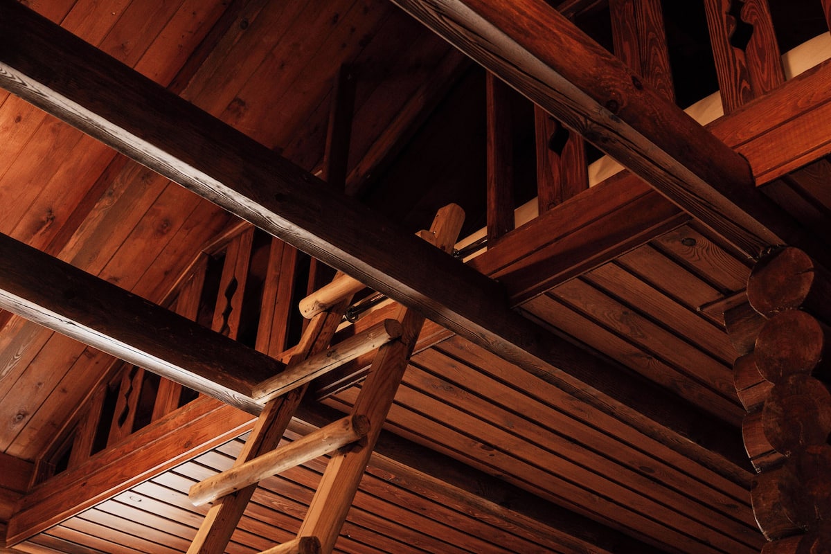 A wooden ceiling structure with beams and a sloped roof.