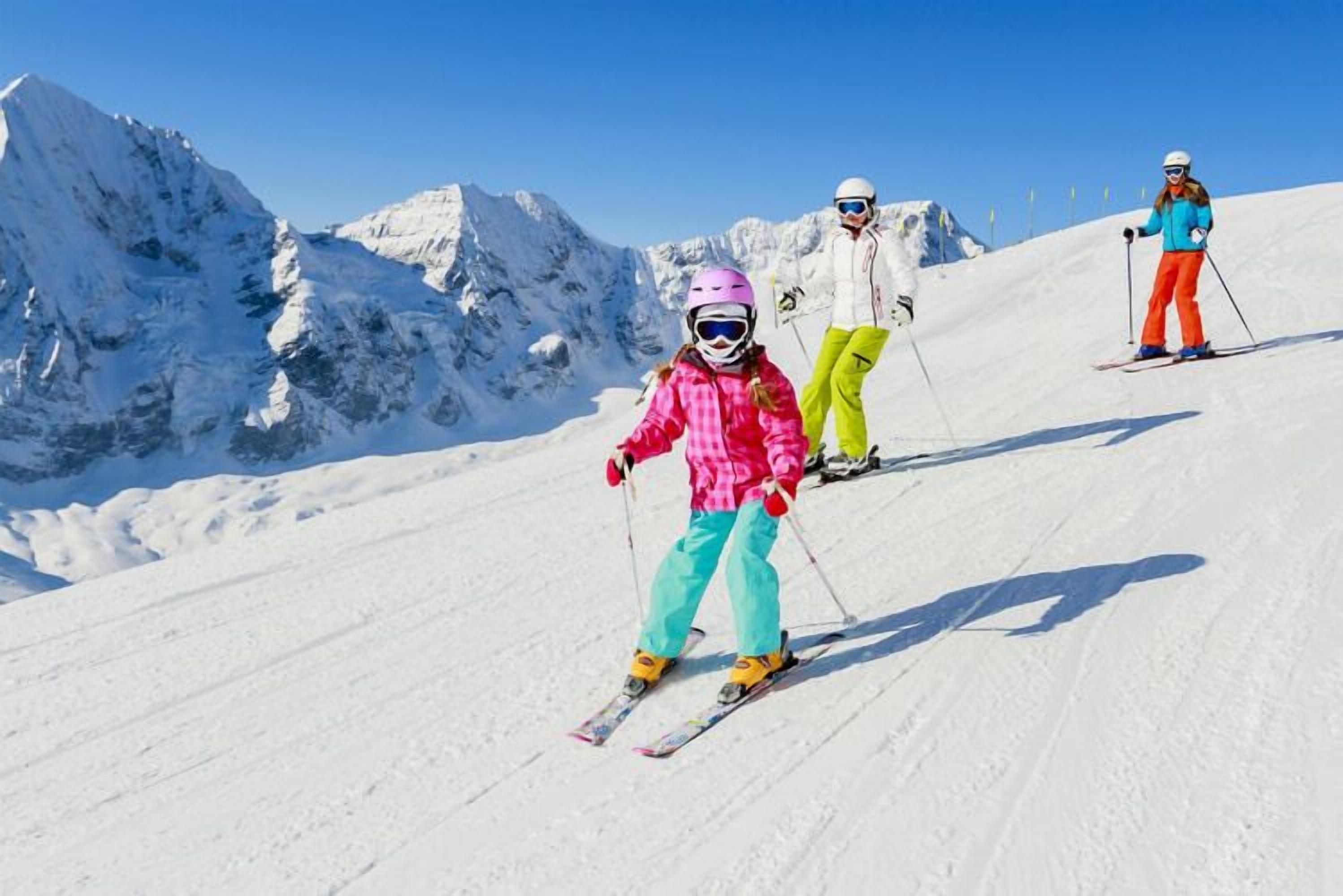 A snowy mountain slope with skiers.
