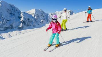 A snowy mountain slope with skiers.