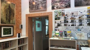 Een bibliotheek met boekenkasten, een houten deur en informatieposters aan de wanden.