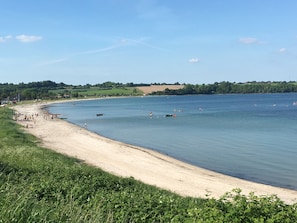 A coastal beach with a sandy shore and calm waters.