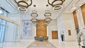 A modern lobby with a marble floor, a reception desk, and a seating area. - Abdali Views Apartments (Amman)