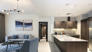 A modern kitchen with a central island, built-in cabinets, and stainless steel appliances. - Abdali Views Apartments (Amman)