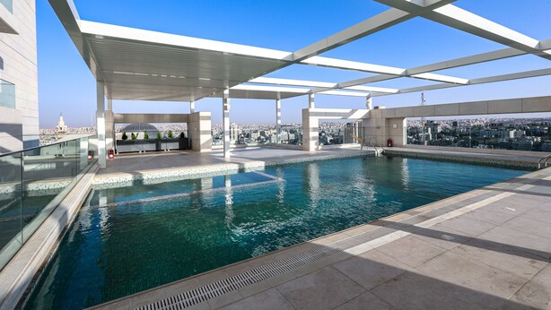 A rooftop swimming pool with a clear view of the cityscape. - Abdali Views Apartments (Amman)