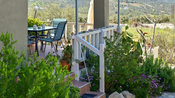 A covered outdoor seating area with a view of the countryside. - Olive Garden house (Καμηλάρι)