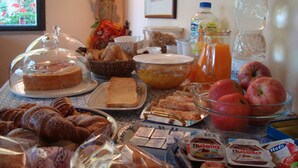 A breakfast buffet with various food items, including bread, pastries, and fruits. - CASALE ASCIOLO (Le Case San Romolo)