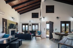 A spacious living area with a fireplace, seating, and a view of the outdoors.