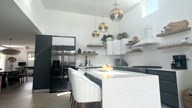 A modern kitchen with a central island, pendant lights, and built-in appliances. - Luxury 5 Bedroom Home, 3 Minute Walk from the Beach (Dorado)