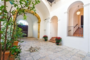 Stroll through the serene courtyard, surrounded by lush greenery and elegant archways.