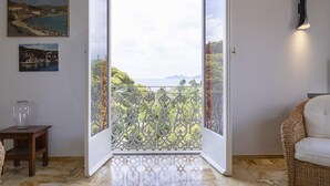A room with a large sliding glass door leading to a balcony with a view of a coastal landscape. - Appartamento a Villa Montuoro by Wonderful Italy (Rapallo)