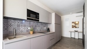 Een moderne keuken met een decoratieve spatwand, een magnetron en een spoelbak.