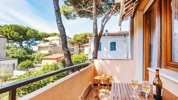 A balcony with a table and chairs, a bottle of wine, and a glass of wine. - Silent Apartment by Wonderful Italy (Sanremo)