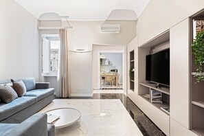 Una sala de estar moderna con sofá, mesa de centro y televisor.