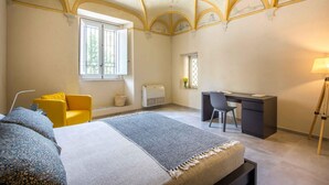Ein Schlafzimmer mit Bett, Schreibtisch, Stuhl und Fenster.