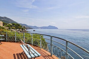 Une promenade en bord de mer, agrémentée de bancs et d’une balustrade d’où l’on peut admirer la mer.