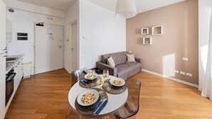 A modern apartment with a dining area, kitchen, and living space. - Residenza Miralago With Pool - Studio Apartment With Lake View (Desenzano del Garda)
