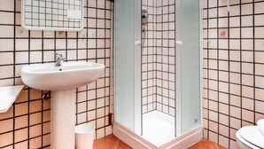 A corner bathroom with a sink, mirror, shower, and toilet. - Nosadella Mezzanine by Wonderful Italy (Bologna)