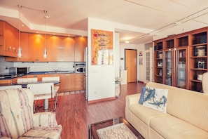 Enjoy a comfortable stay in this cozy living space with a fully equipped kitchen, dining area, and plush sofa.