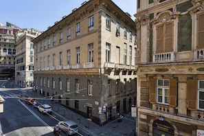 A street view of a building with multiple floors, large windows, and a ground floor with a visible storefront.
