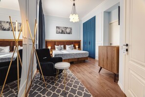 Ein Hotelzimmer mit zwei Betten, einem kleinen runden Tisch, einem Stuhl, einem Holzschrank und einem gemusterten Teppich.