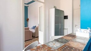 A room with a tiled floor, a white cabinet, and a blue wall. - Funky flat (Palermo)