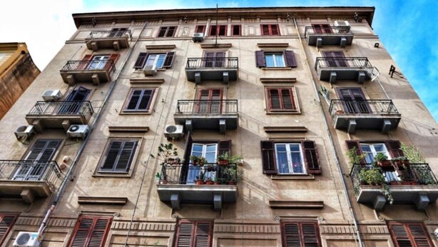 A multi-story building with balconies, air conditioning units, and a clear sky. - Funky flat (Palermo)
